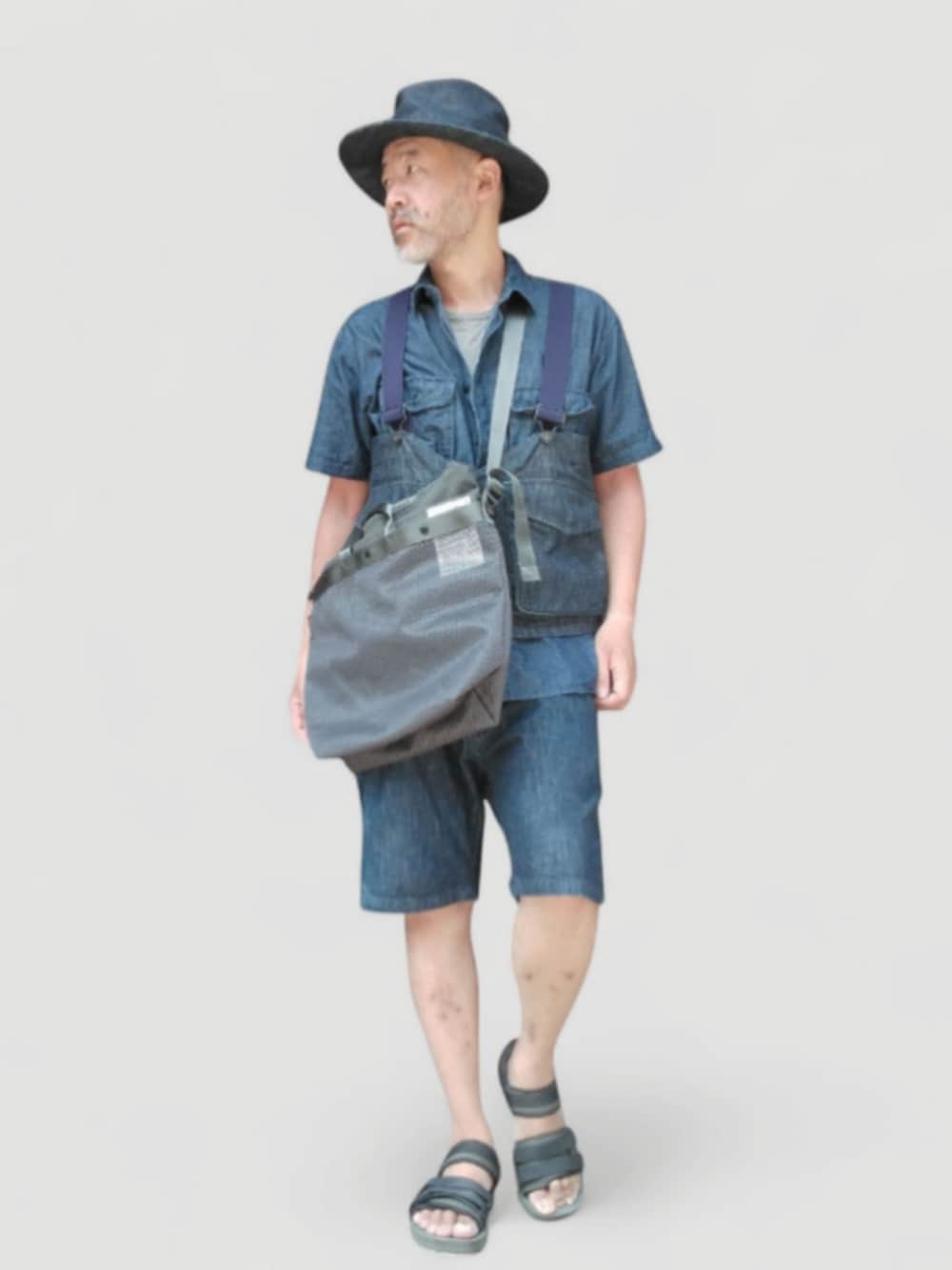 ブラック系のサンダル、ブラック系のショルダーバッグ、ブルー系のベストを着用したメンズの夏コーディネートの4枚目の写真