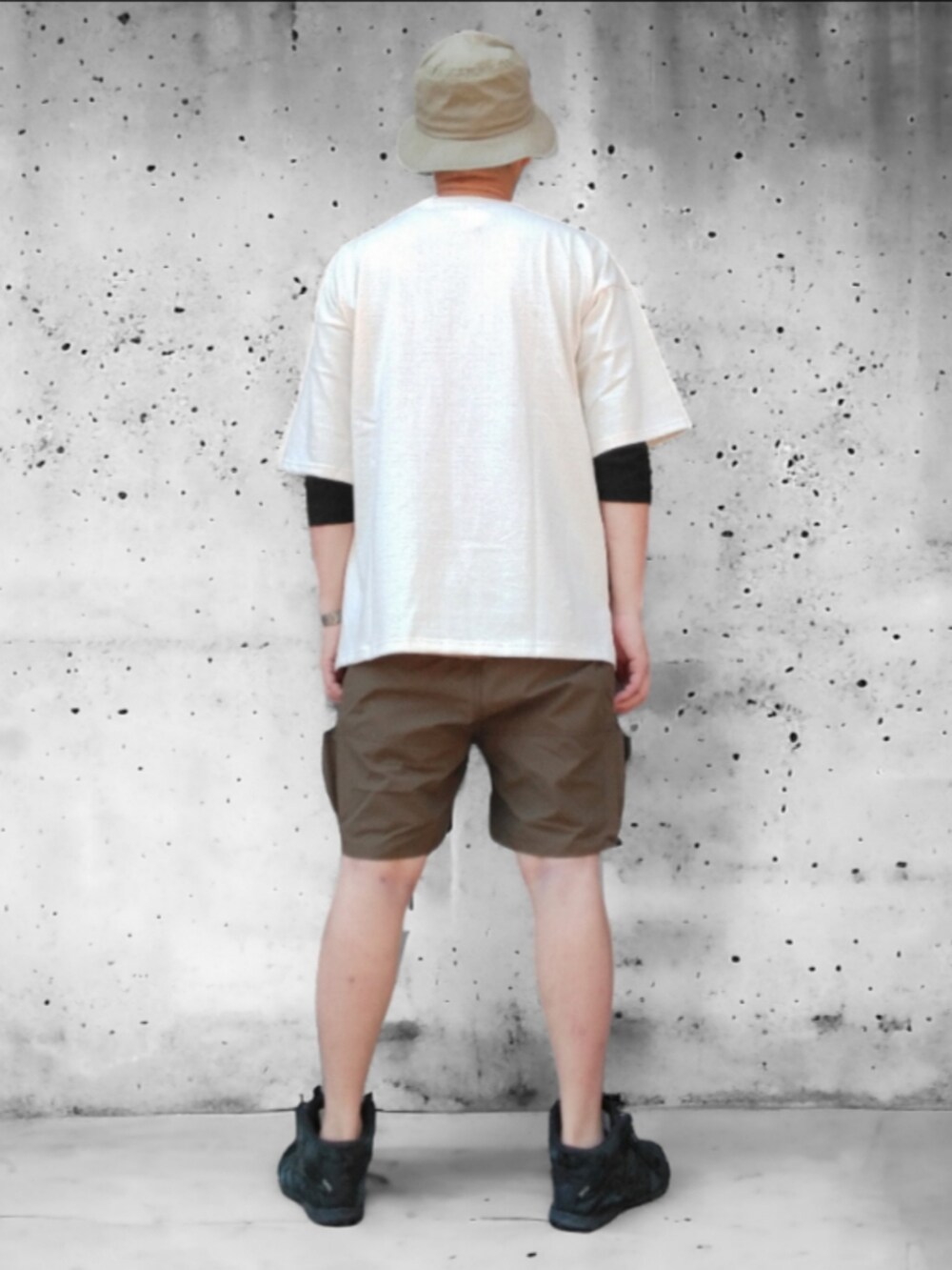 グリーン系のパンツ、ホワイト系のTシャツ/カットソー、グリーン系のハットを着用したメンズの春コーディネートの5枚目の写真