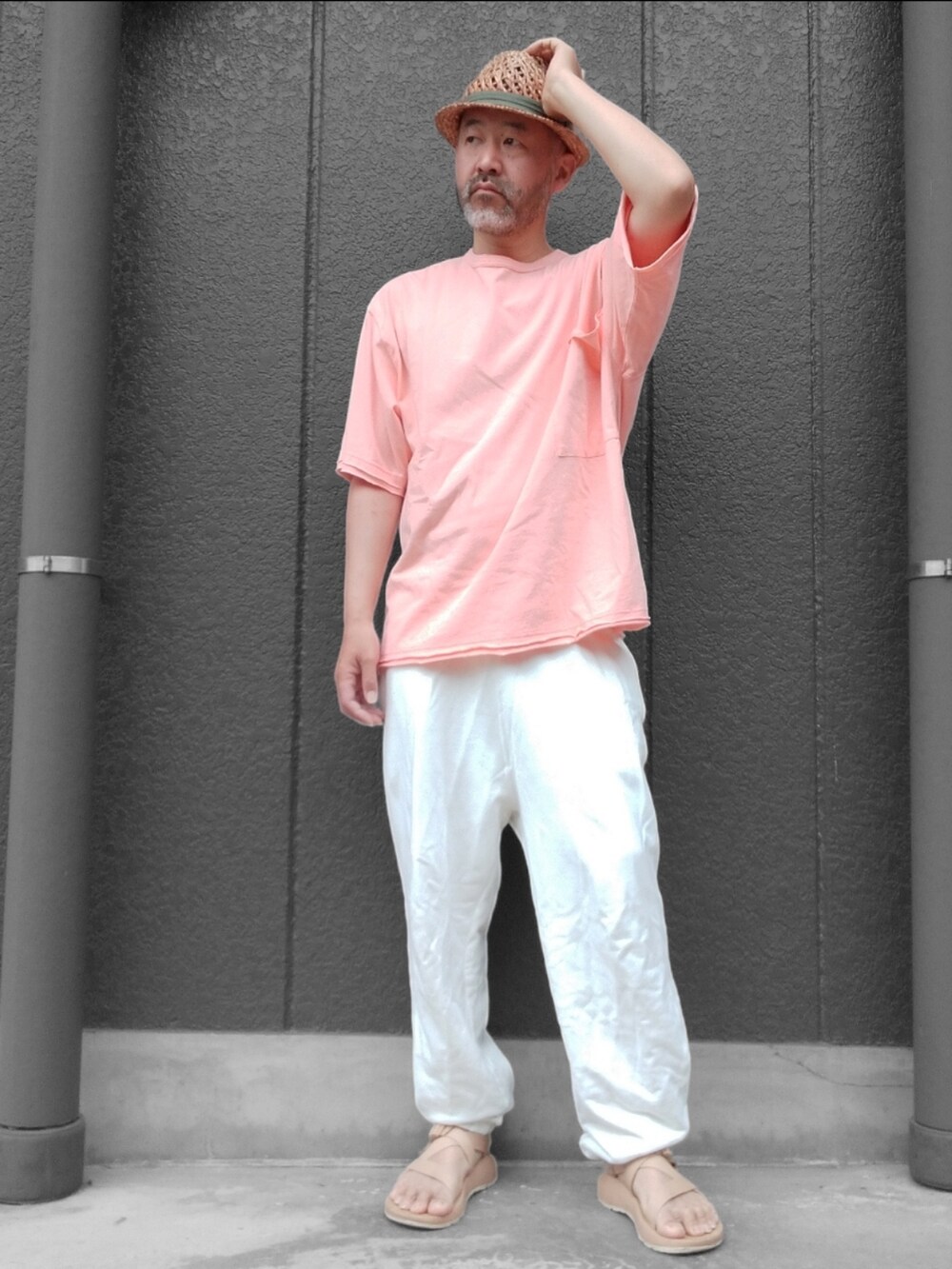 ホワイト系のスウェットパンツ、ベージュ系のサンダル、オレンジ系のTシャツ/カットソーを着用したメンズの夏コーディネートの4枚目の写真