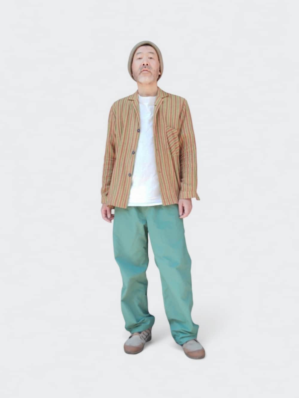 グリーン系のパンツ、ベージュ系のスニーカー、イエロー系のシャツ/ブラウスを着用したメンズの春コーディネートの2枚目の写真