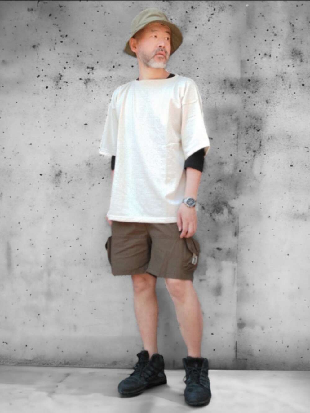 グリーン系のパンツ、ホワイト系のTシャツ/カットソー、グリーン系のハットを着用したメンズの春コーディネートの4枚目の写真