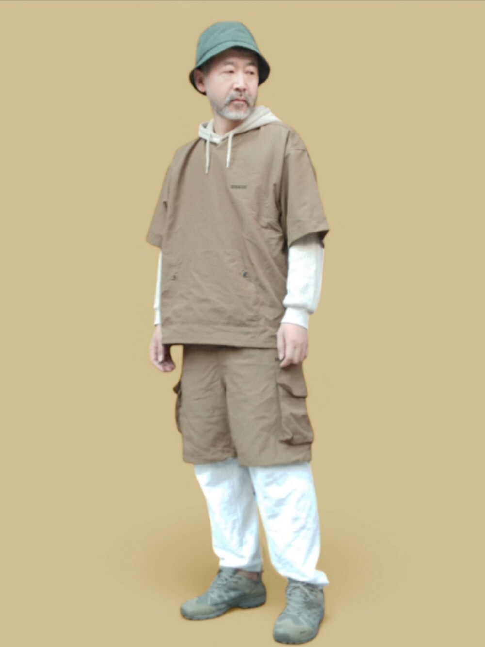 ホワイト系のスウェットパンツ、ベージュ系のパーカー、グリーン系のスニーカーを着用したメンズの冬コーディネートの4枚目の写真