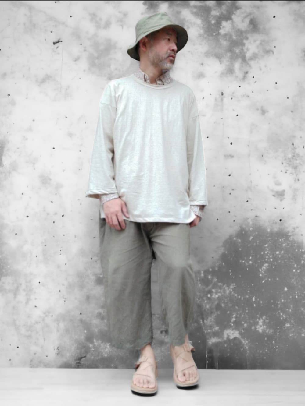 グリーン系のその他パンツ、ベージュ系のサンダル、ホワイト系のTシャツ/カットソーを着用したメンズの春コーディネートの3枚目の写真