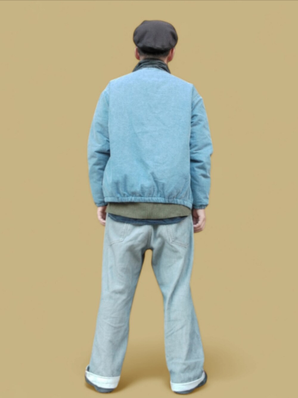 グレー系のデニムパンツ、ブラック系のスニーカー、グリーン系のニット/セーターを着用したメンズの秋コーディネートの5枚目の写真