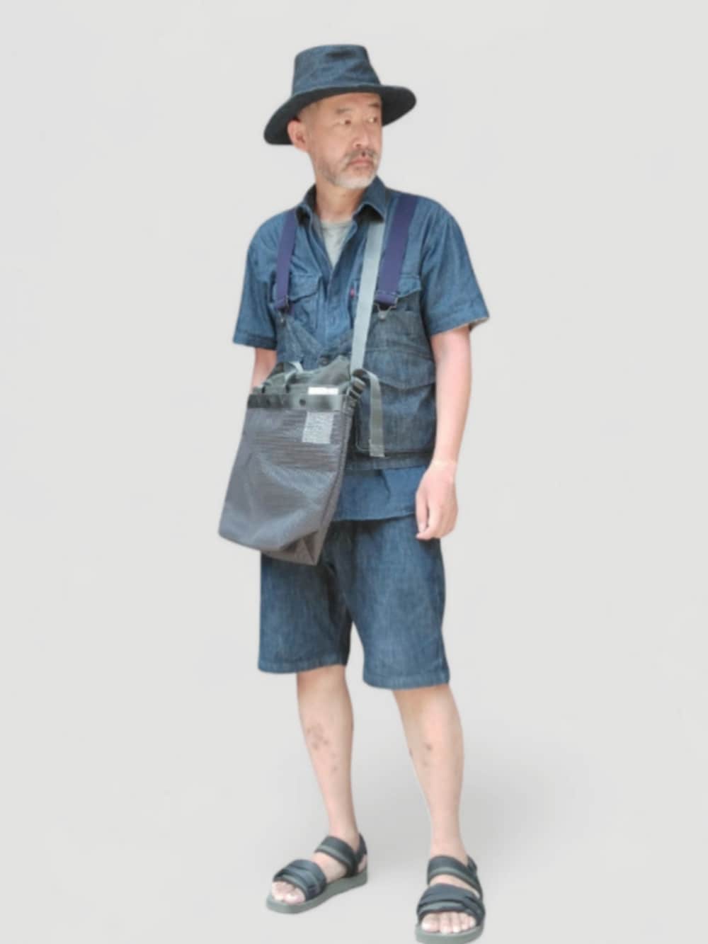 ブラック系のサンダル、ブラック系のショルダーバッグ、ブルー系のベストを着用したメンズの夏コーディネートの3枚目の写真