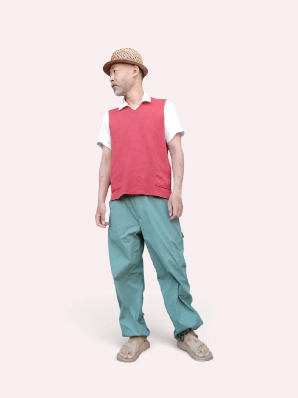 グリーン系のパンツ、ベージュ系のサンダル、レッド系のベストを着用したメンズの夏コーディネートの3枚目の写真
