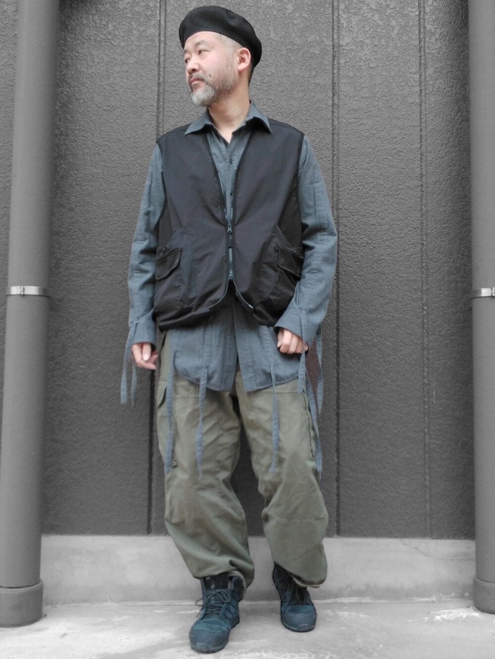 グリーン系のカーゴパンツ、ブラック系のスニーカー、ブラック系のベストを着用したメンズの冬コーディネートの3枚目の写真