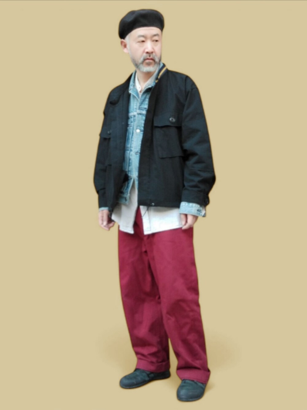 ブラック系のスニーカー、レッド系のチノパンツ、ブルー系のデニムジャケットを着用したメンズの春コーディネートの2枚目の写真