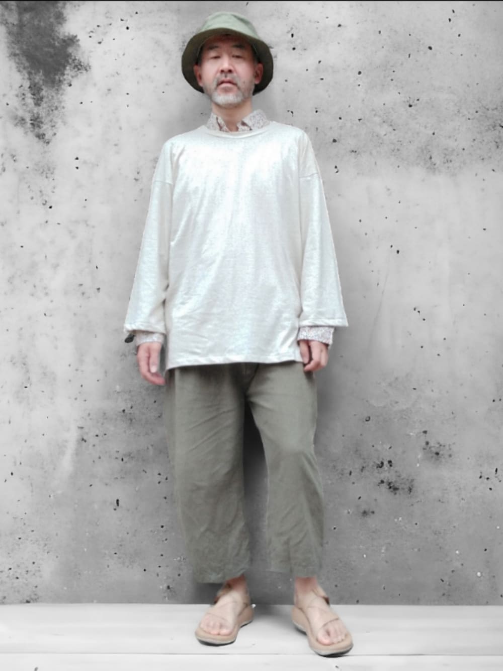 グリーン系のその他パンツ、ベージュ系のサンダル、ホワイト系のTシャツ/カットソーを着用したメンズの春コーディネートの2枚目の写真
