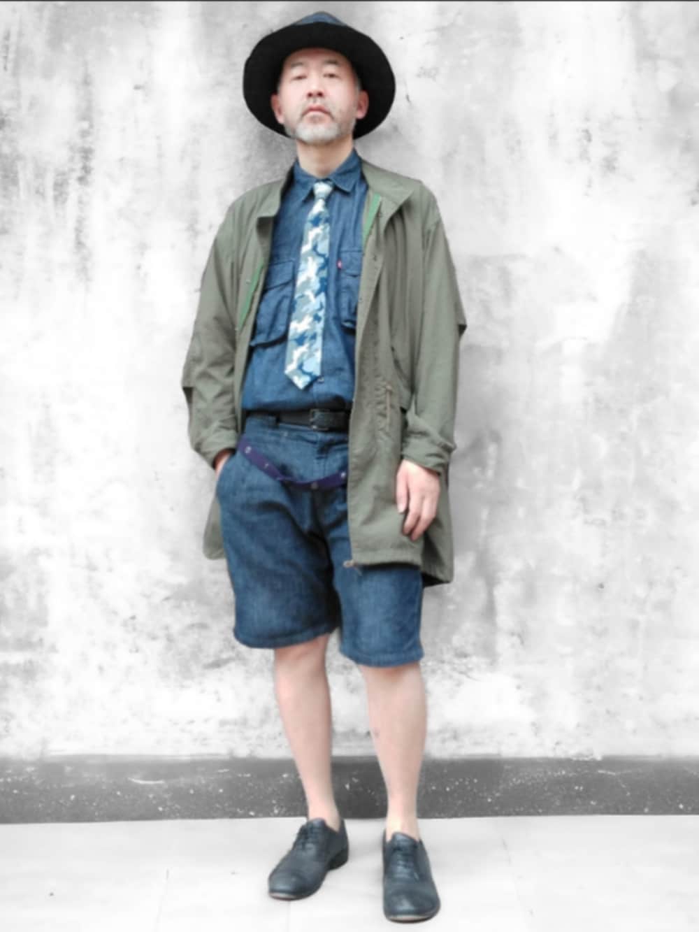 グリーン系のモッズコート、ブルー系のデニムパンツ、ブルー系のハットを着用したメンズの春コーディネートの4枚目の写真