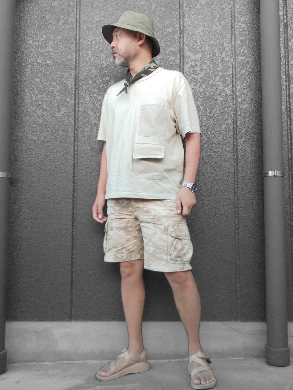 ベージュ系のTシャツ/カットソー、ベージュ系のカーゴパンツ、ベージュ系のサンダルを着用したメンズの夏コーディネートの4枚目の写真
