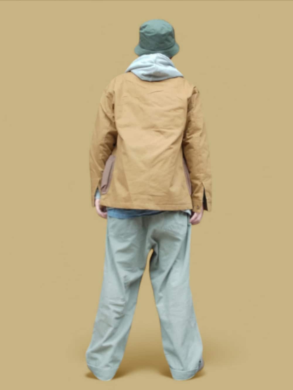 グリーン系のカーゴパンツ、グリーン系のスニーカー、イエロー系のカバーオールを着用したメンズの冬コーディネートの5枚目の写真