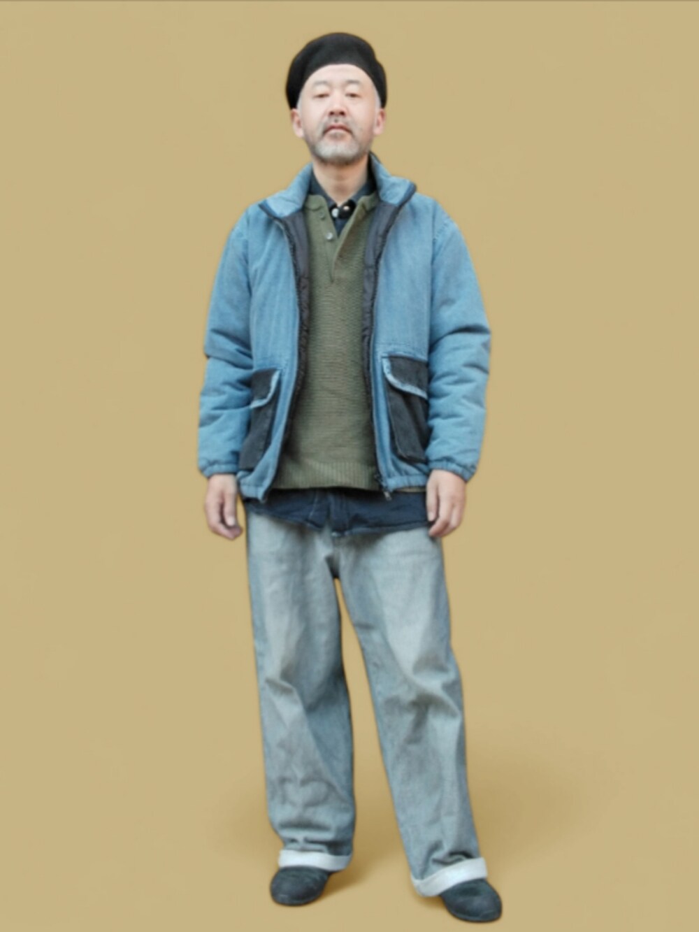 グレー系のデニムパンツ、ブラック系のスニーカー、グリーン系のニット/セーターを着用したメンズの秋コーディネートの3枚目の写真