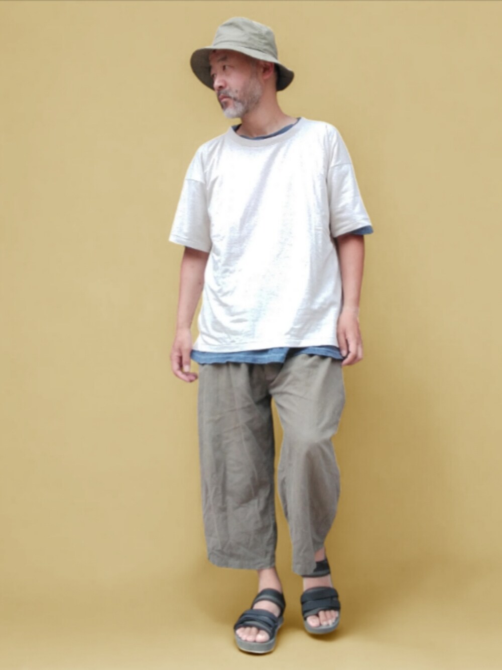 グリーン系のサンダル、グリーン系のその他パンツ、ホワイト系のTシャツ/カットソーを着用したメンズの夏コーディネートの2枚目の写真