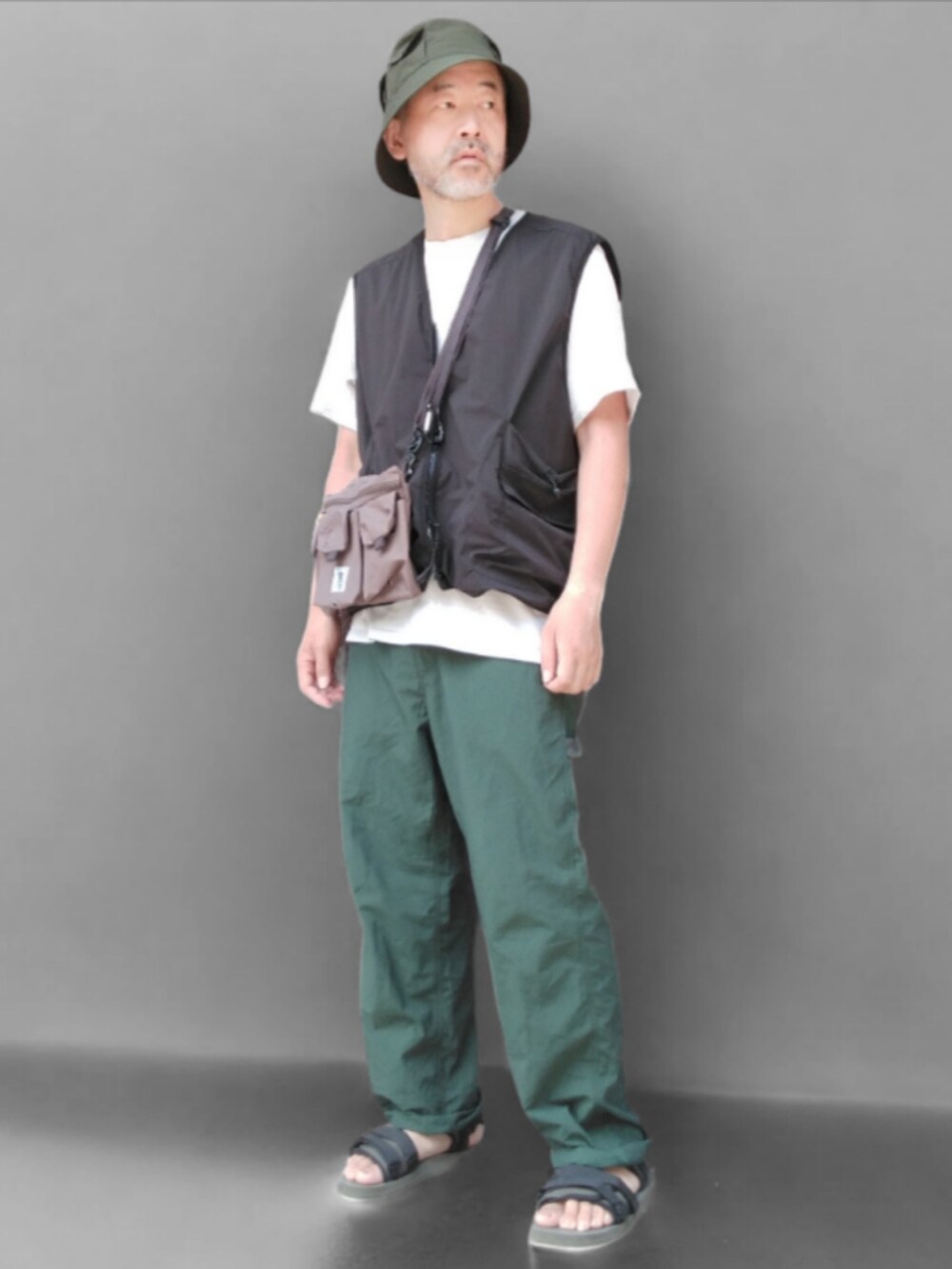 グリーン系のその他パンツ、ブラック系のベスト、グリーン系のサンダルを着用したメンズの夏コーディネートの4枚目の写真