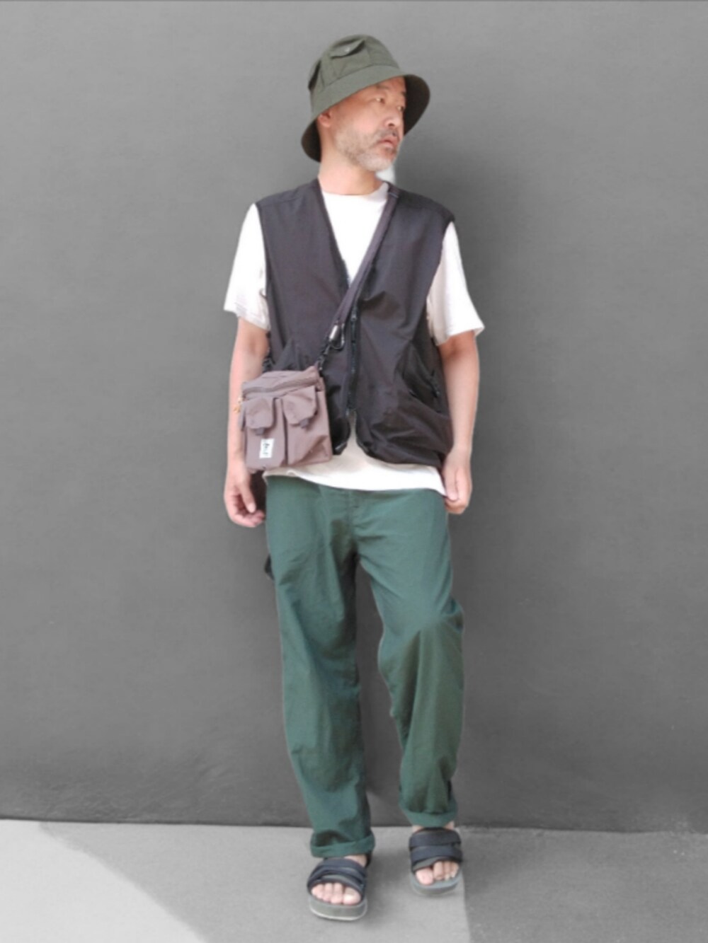 グリーン系のその他パンツ、ブラック系のベスト、グリーン系のサンダルを着用したメンズの夏コーディネートの3枚目の写真