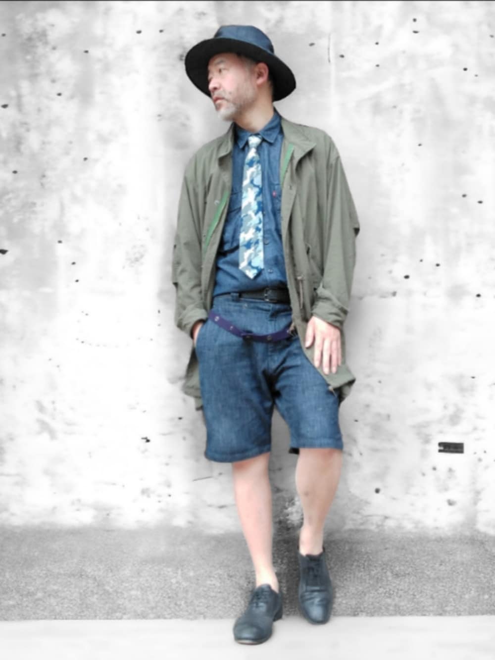 グリーン系のモッズコート、ブルー系のデニムパンツ、ブルー系のハットを着用したメンズの春コーディネートの3枚目の写真