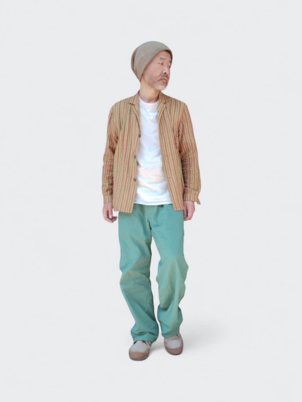 グリーン系のパンツ、ベージュ系のスニーカー、イエロー系のシャツ/ブラウスを着用したメンズの春コーディネートの3枚目の写真