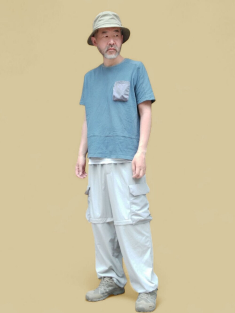 ブルー系のTシャツ/カットソー、グレー系のカーゴパンツ、グリーン系のスニーカーを着用したメンズの夏コーディネートの4枚目の写真