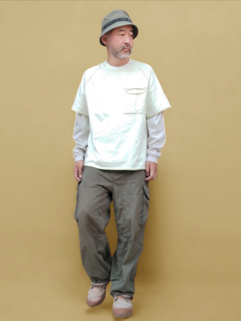 グリーン系のカーゴパンツ、ベージュ系のスニーカー、ホワイト系のTシャツ/カットソーを着用したメンズの夏コーディネートの2枚目の写真