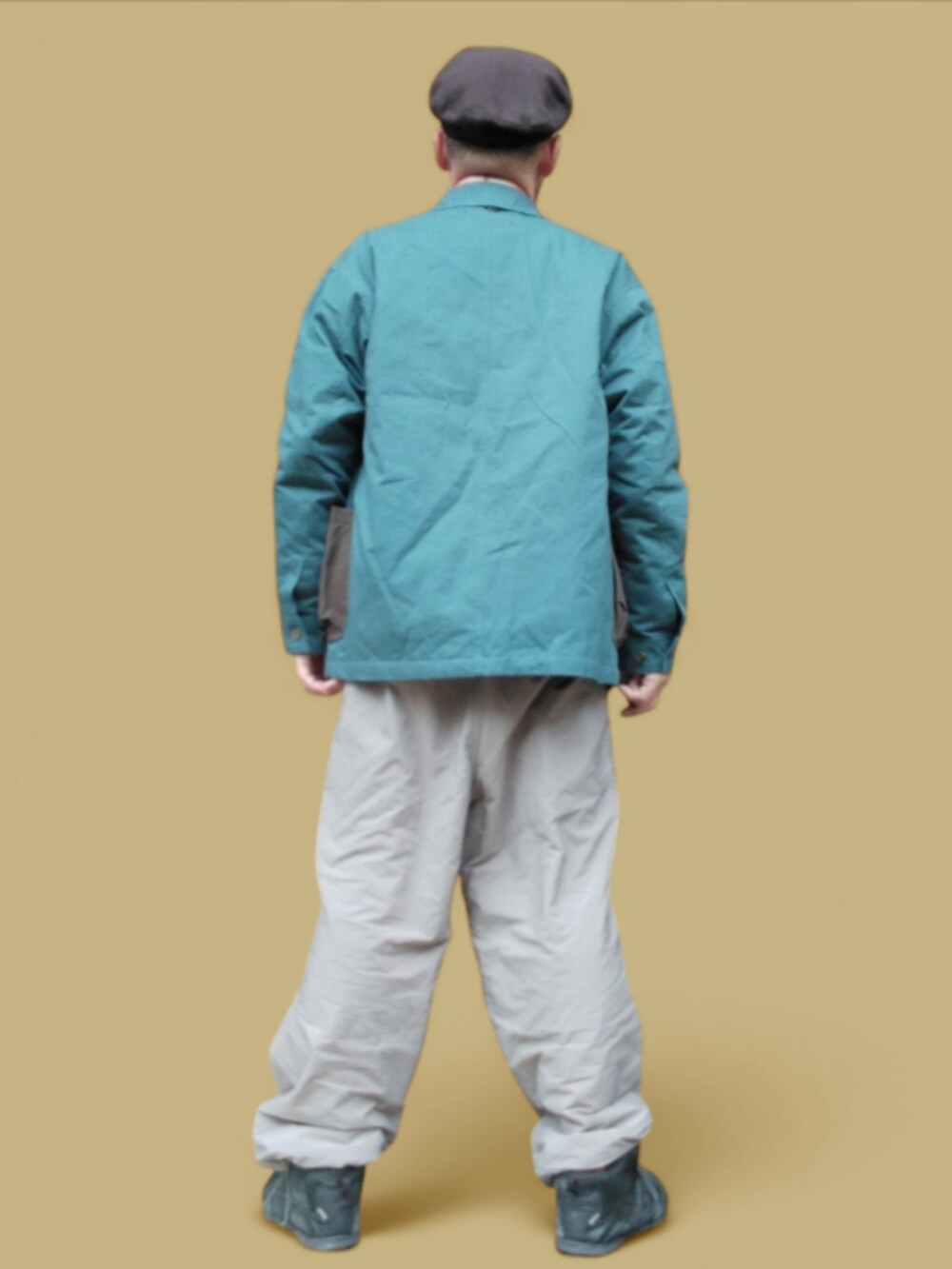 グレー系のパンツ、ブラック系のスニーカー、オレンジ系のシャツ/ブラウスを着用したメンズの冬コーディネートの5枚目の写真