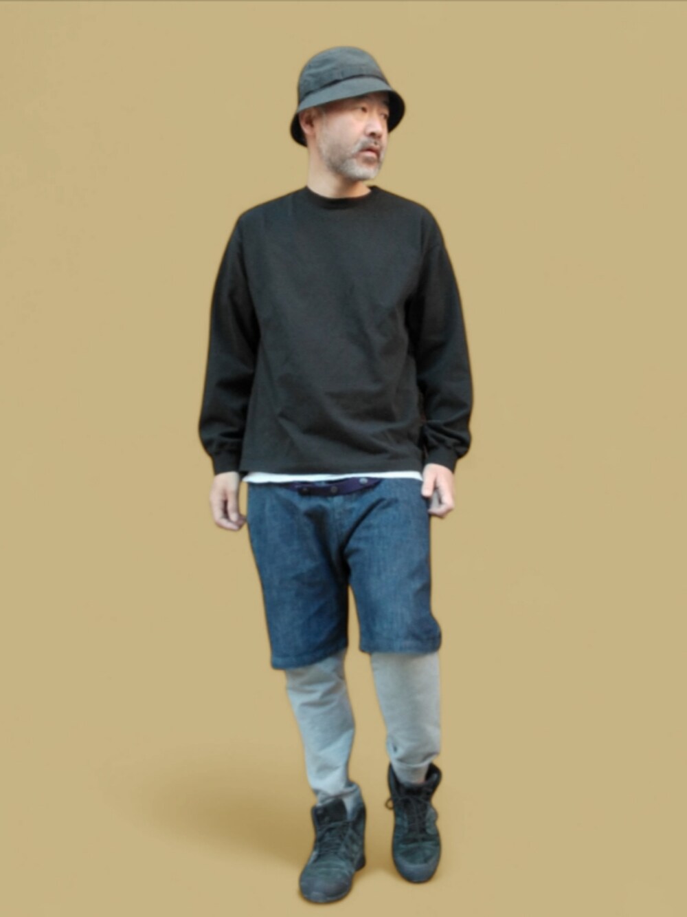 ブルー系のデニムパンツ、ブラック系のスニーカー、ブラック系のハットを着用したメンズの秋コーディネートの3枚目の写真