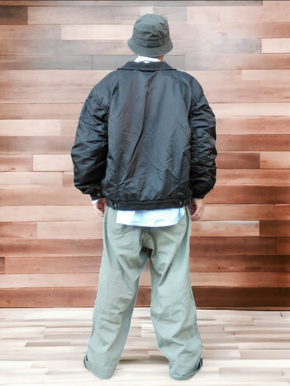 グリーン系のカーゴパンツ、ブラック系のスニーカー、ブラック系のブルゾンを着用したメンズの秋コーディネートの5枚目の写真