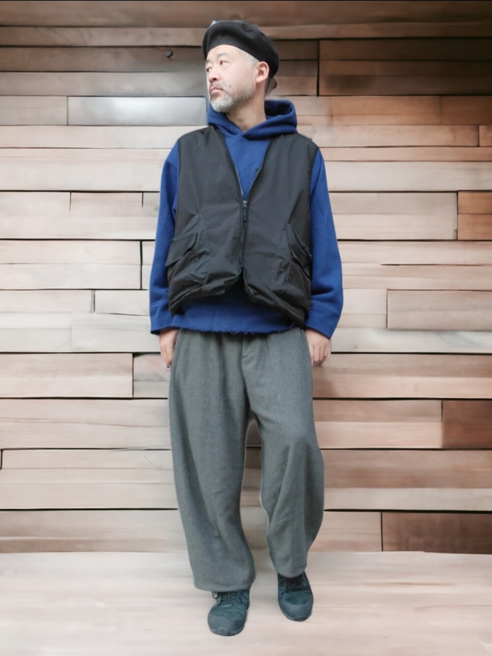 ブラック系のスニーカー、グレー系のパンツ、ブラック系のベストを着用したメンズの秋コーディネートの4枚目の写真