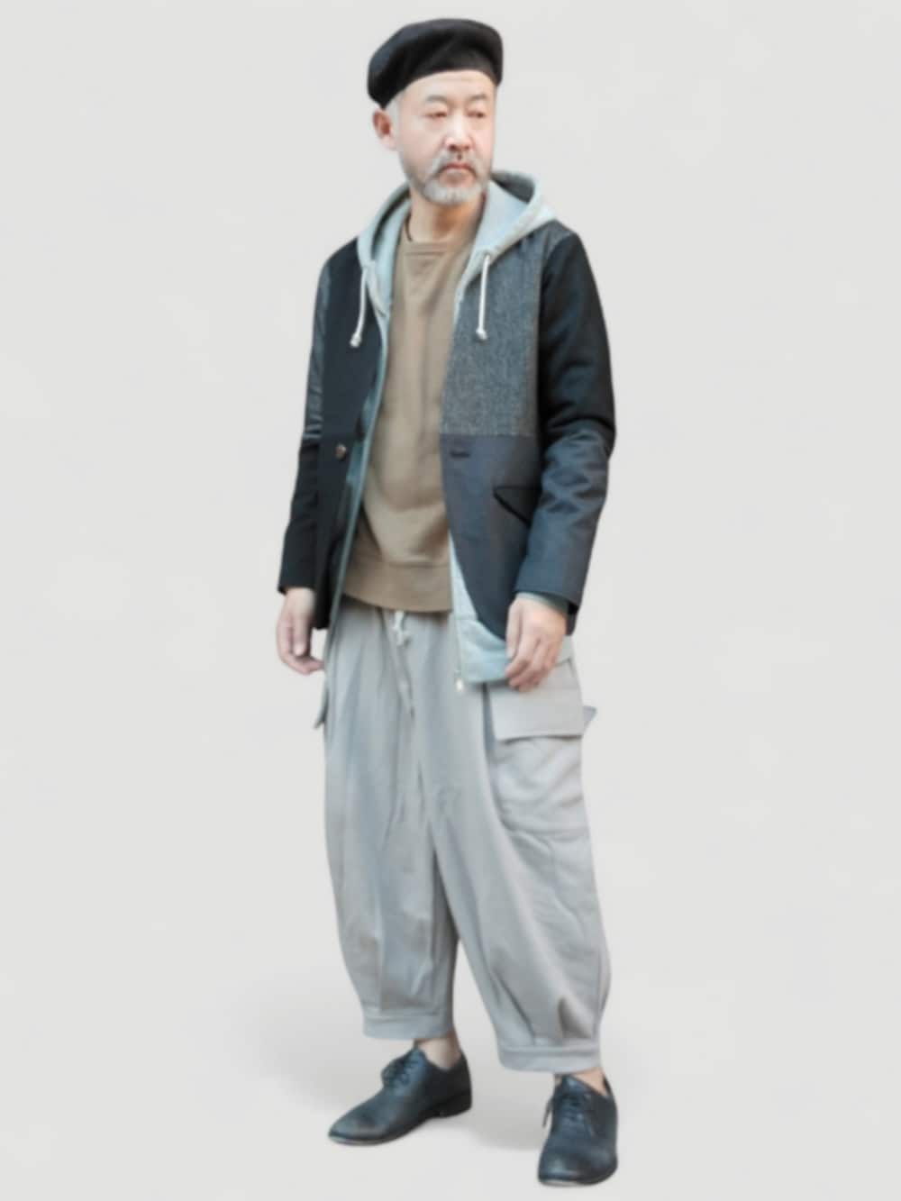 グレー系のスウェットパンツ、ベージュ系のスウェット、ブラック系のノーカラージャケットを着用したメンズの冬コーディネートの2枚目の写真