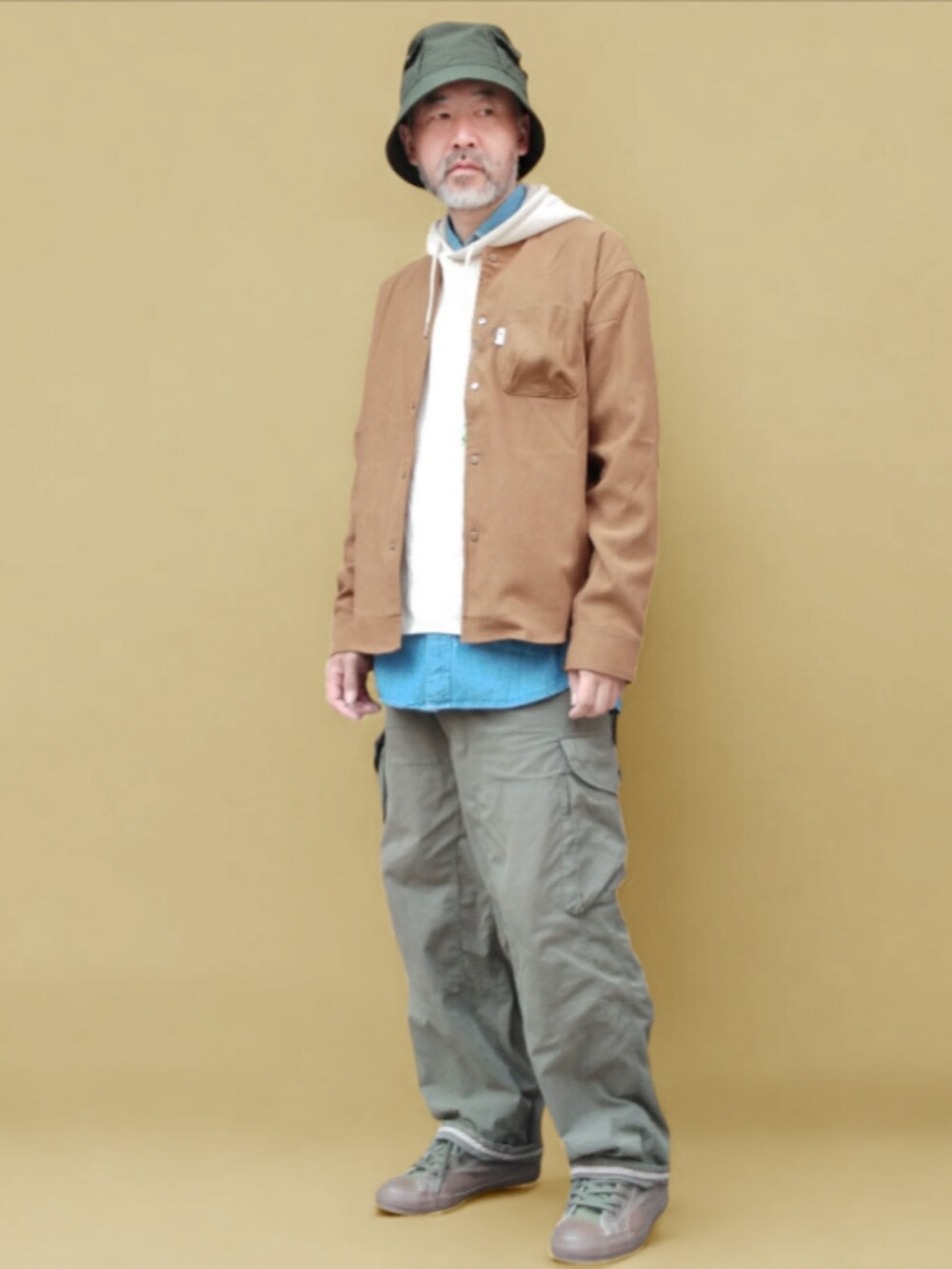 グリーン系のカーゴパンツ、グリーン系のスニーカー、ブラウン系のシャツ/ブラウスを着用したメンズの秋コーディネートの4枚目の写真