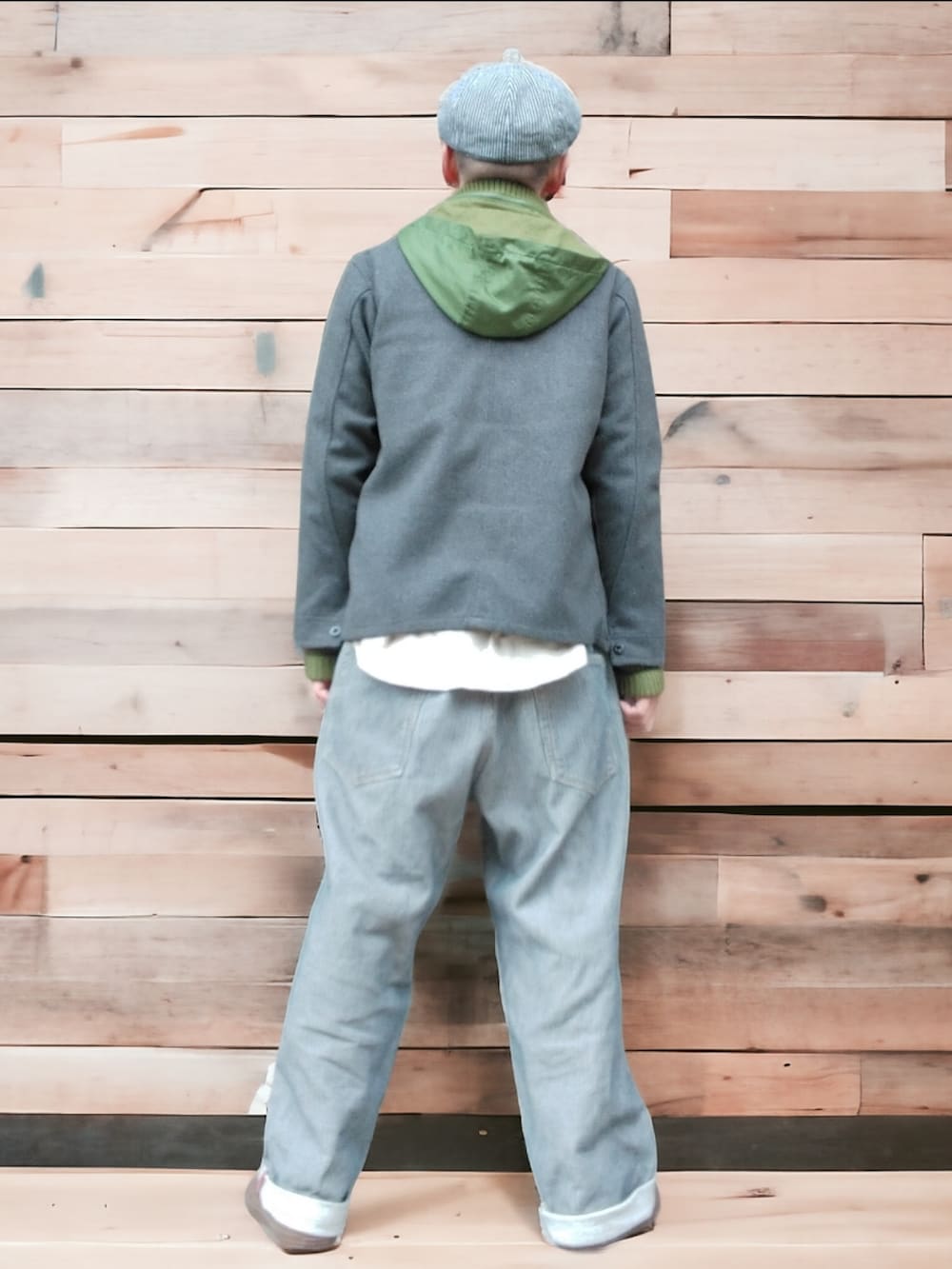 グレー系のデニムパンツ、グリーン系のスニーカー、グレー系のノーカラージャケットを着用したメンズの冬コーディネートの5枚目の写真