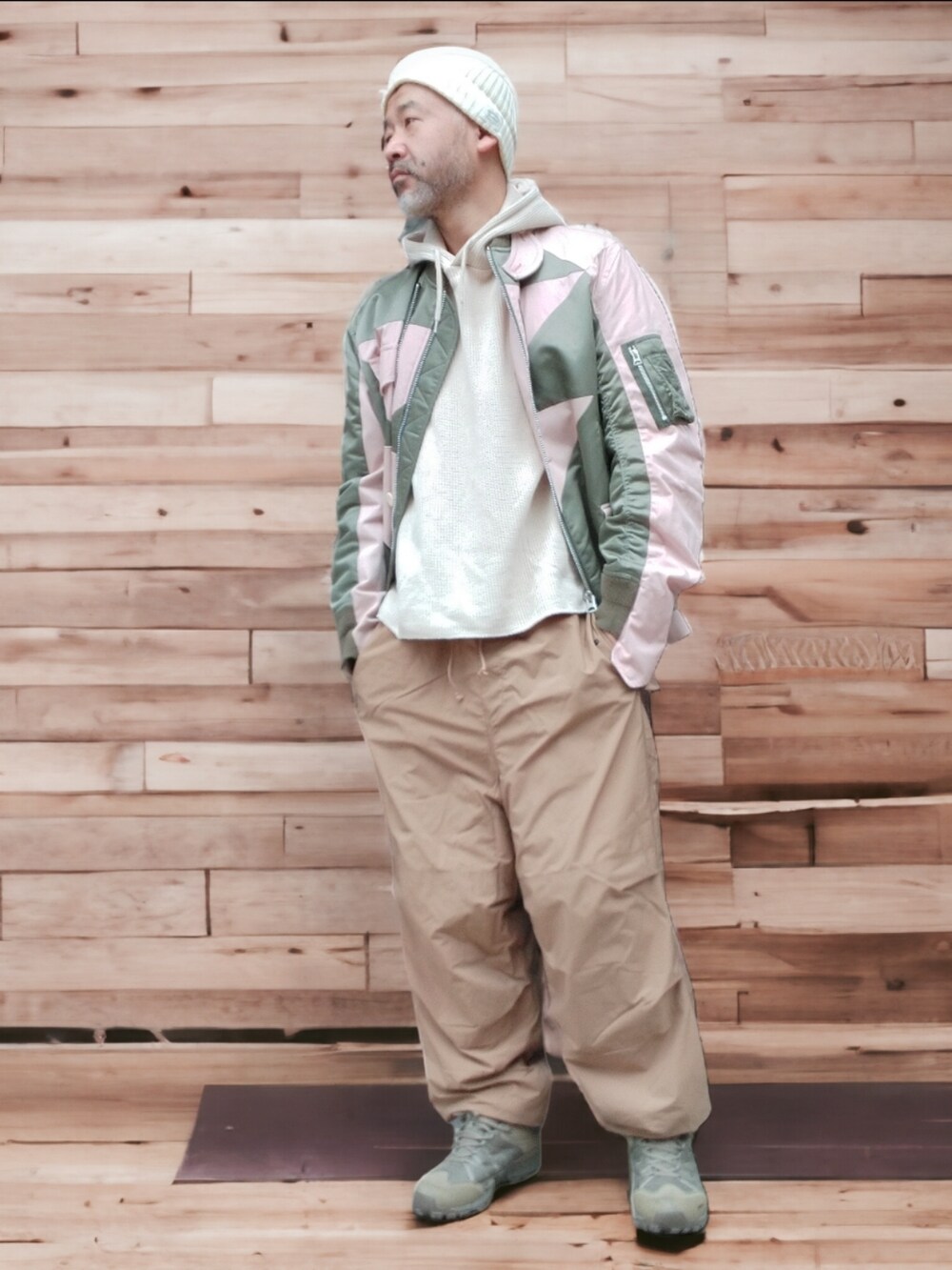 ベージュ系のパンツ、グリーン系のスニーカー、ピンク系のジャケット/アウターを着用したメンズの冬コーディネートの3枚目の写真