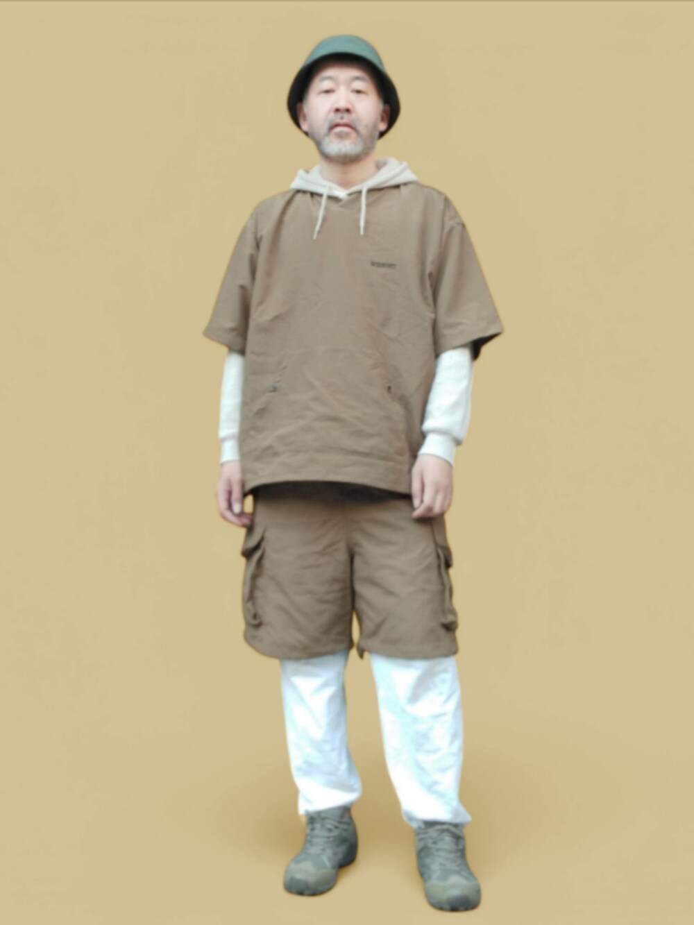 ホワイト系のスウェットパンツ、ベージュ系のパーカー、グリーン系のスニーカーを着用したメンズの冬コーディネートの3枚目の写真