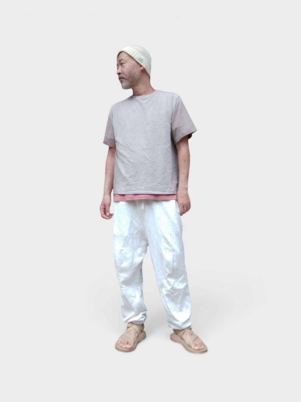 ホワイト系のスウェットパンツ、ベージュ系のサンダル、ベージュ系のTシャツ/カットソーを着用したメンズの夏コーディネートの2枚目の写真
