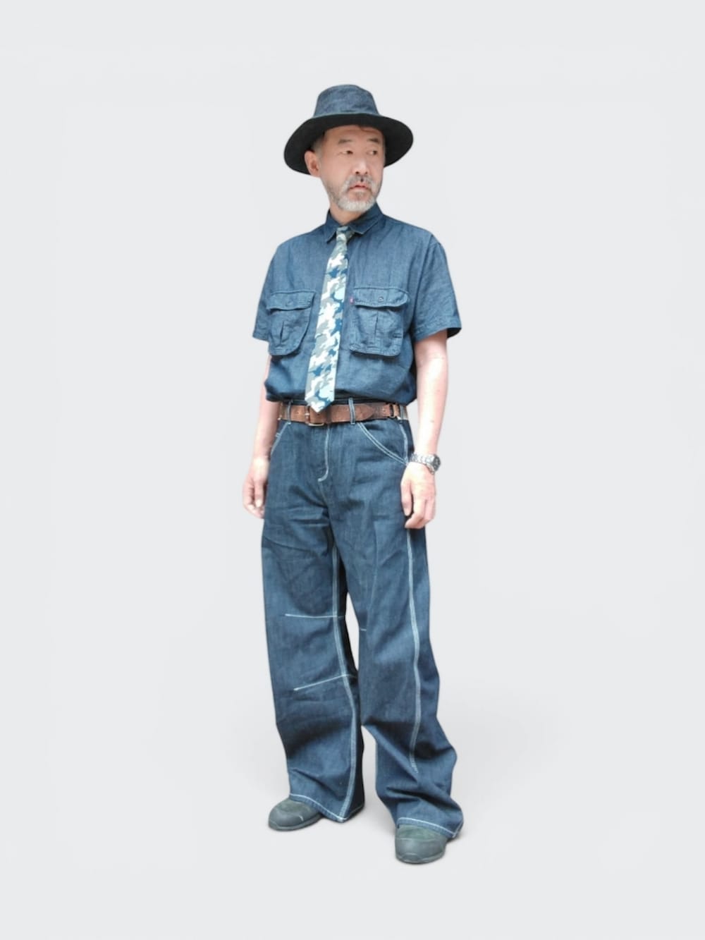 ブルー系のデニムパンツ、ブラック系のスニーカー、ブルー系のシャツ/ブラウスを着用したメンズの夏コーディネートの3枚目の写真