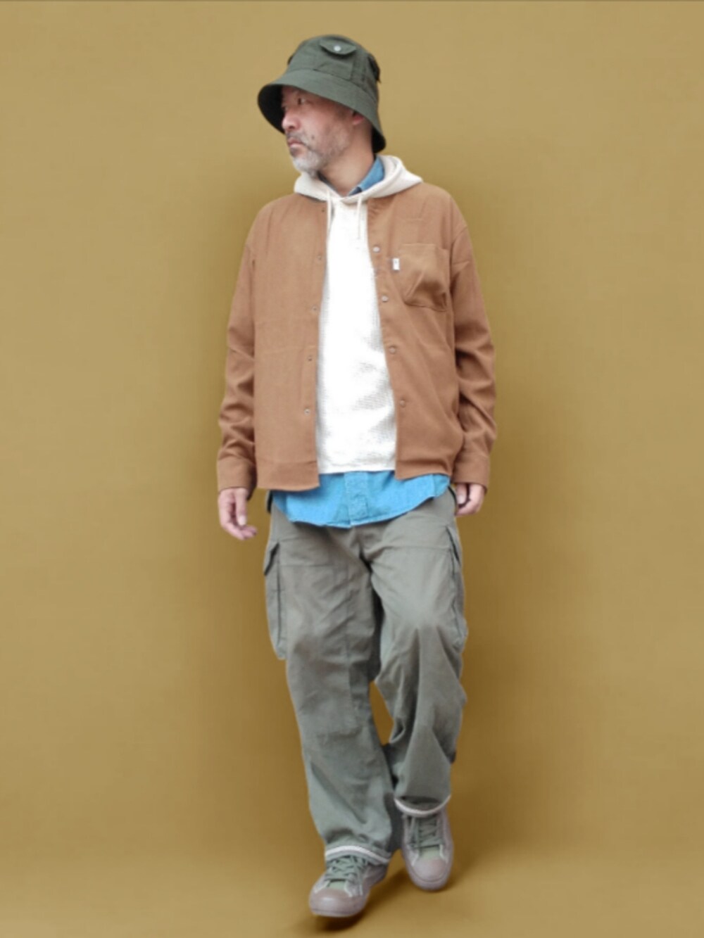 グリーン系のカーゴパンツ、グリーン系のスニーカー、ブラウン系のシャツ/ブラウスを着用したメンズの秋コーディネートの2枚目の写真