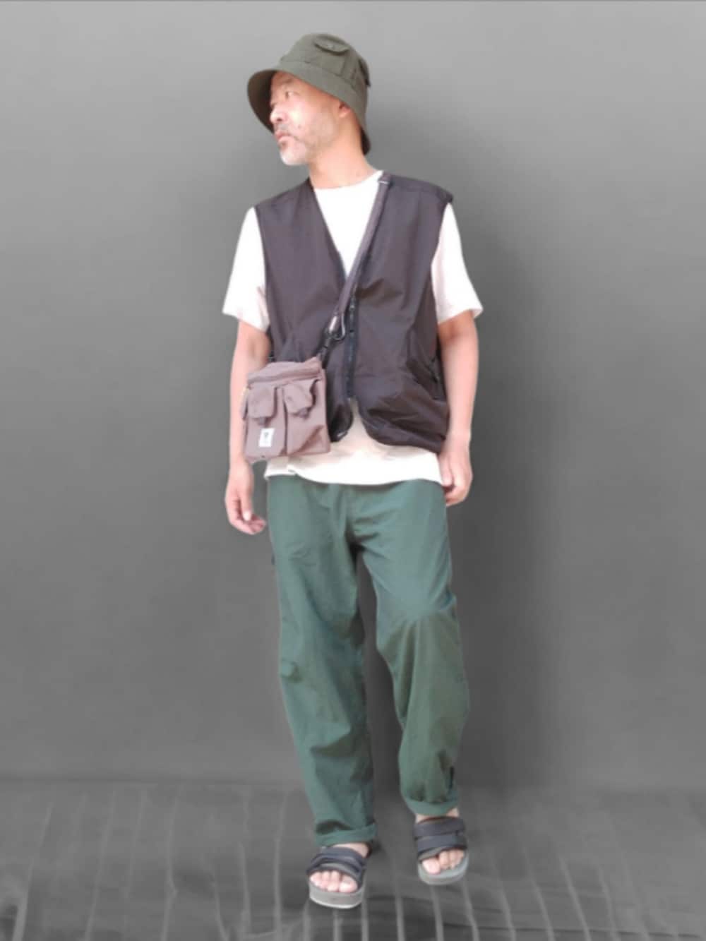 グリーン系のその他パンツ、ブラック系のベスト、グリーン系のサンダルを着用したメンズの夏コーディネートの2枚目の写真