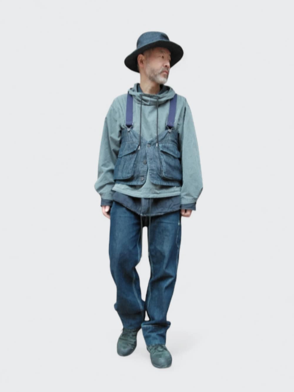 ブルー系のデニムパンツ、ブラック系のスニーカー、ブルー系のベストを着用したメンズの冬コーディネートの2枚目の写真