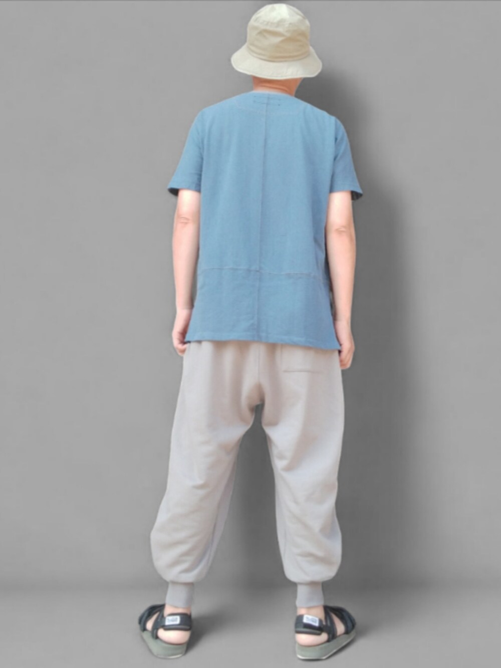 グレー系のスウェットパンツ、グリーン系のサンダル、ブルー系のTシャツ/カットソーを着用したメンズの夏コーディネートの5枚目の写真