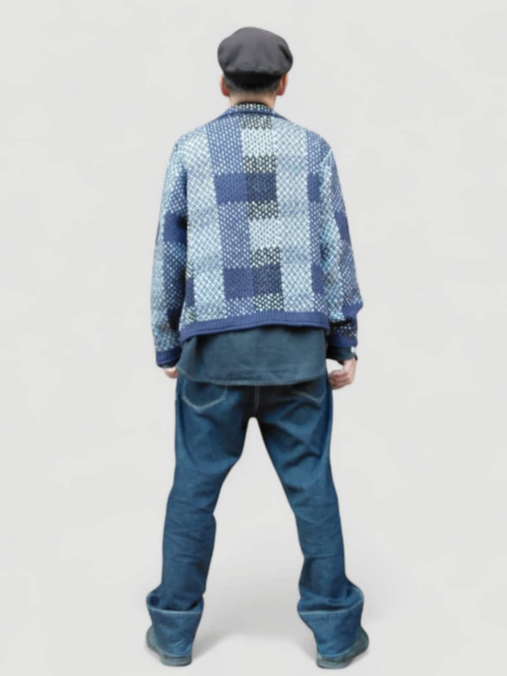 ブラック系のスニーカー、ブルー系のデニムパンツ、ブルー系のニット/セーターを着用したメンズの冬コーディネートの5枚目の写真