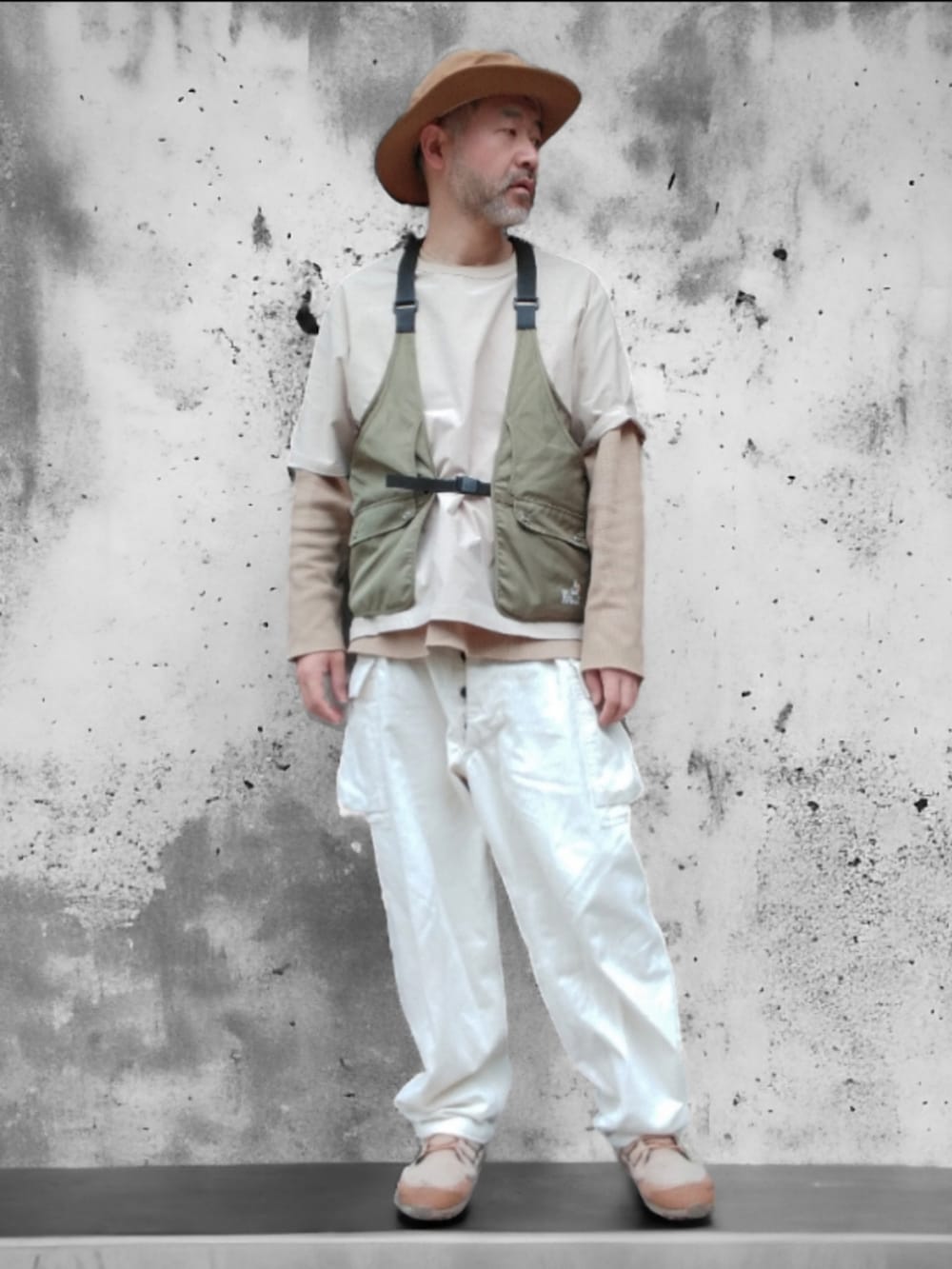 ベージュ系のその他トップス、グリーン系のベスト、ホワイト系のカーゴパンツを着用したメンズの春コーディネートの4枚目の写真