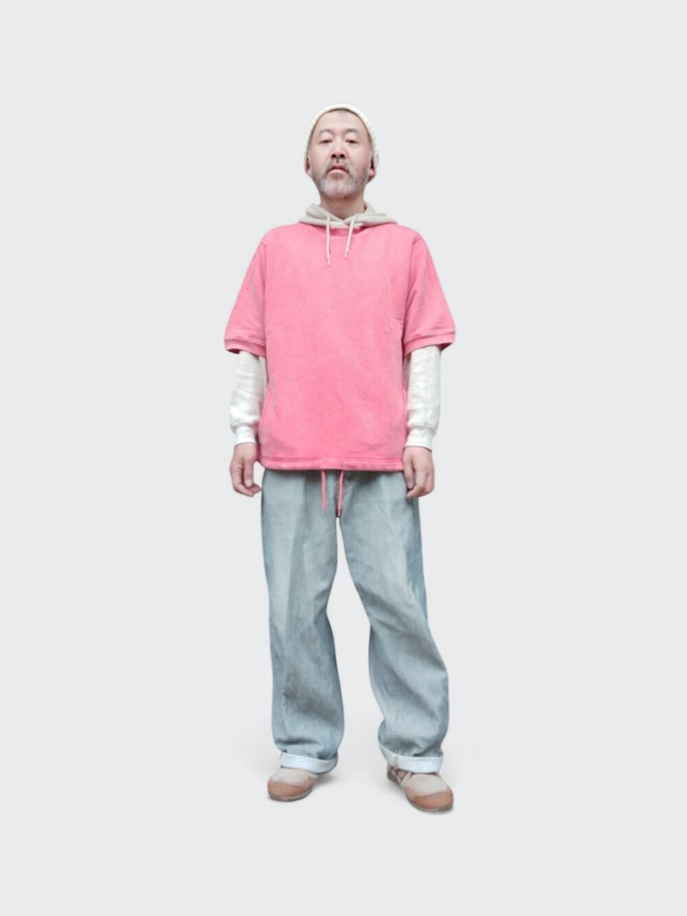 ピンク系のスウェット、グレー系のデニムパンツ、ベージュ系のスニーカーを着用したメンズの春コーディネートの2枚目の写真