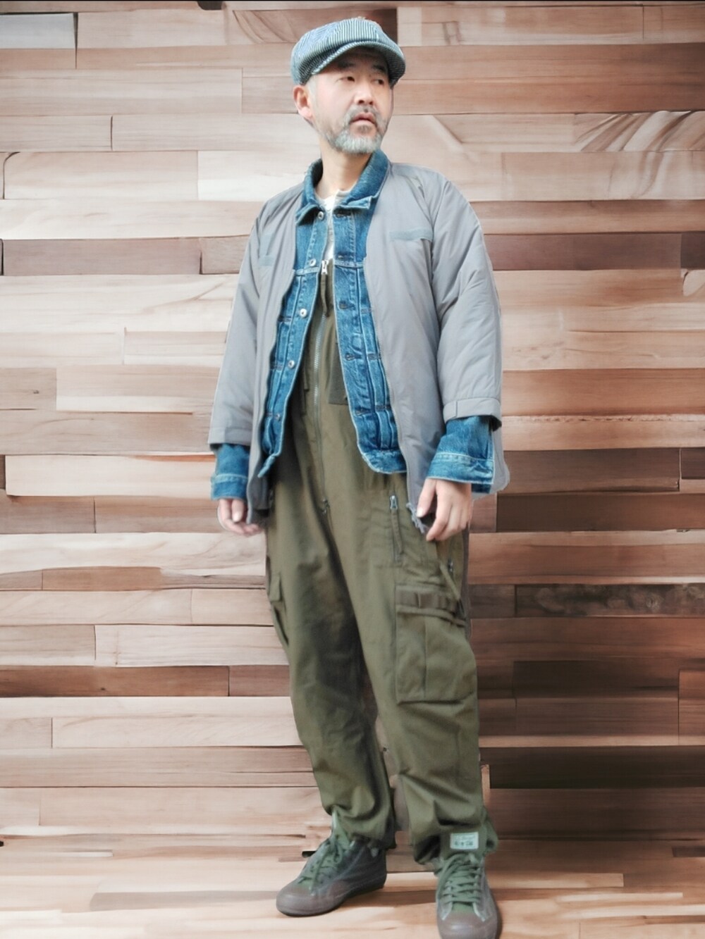 グリーン系のサロペット/オーバーオール、ブルー系のデニムジャケット、グリーン系のスニーカーを着用したメンズの冬コーディネートの2枚目の写真