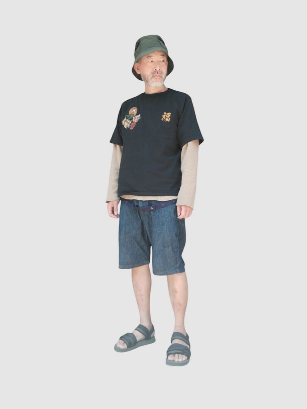 ブルー系のデニムパンツ、ブラック系のサンダル、ブラック系のTシャツ/カットソーを着用したメンズの夏コーディネートの2枚目の写真