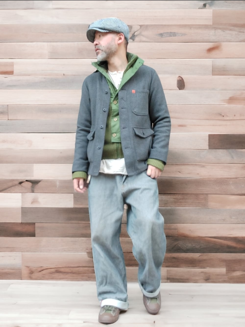 グレー系のデニムパンツ、グリーン系のスニーカー、グレー系のノーカラージャケットを着用したメンズの冬コーディネートの2枚目の写真