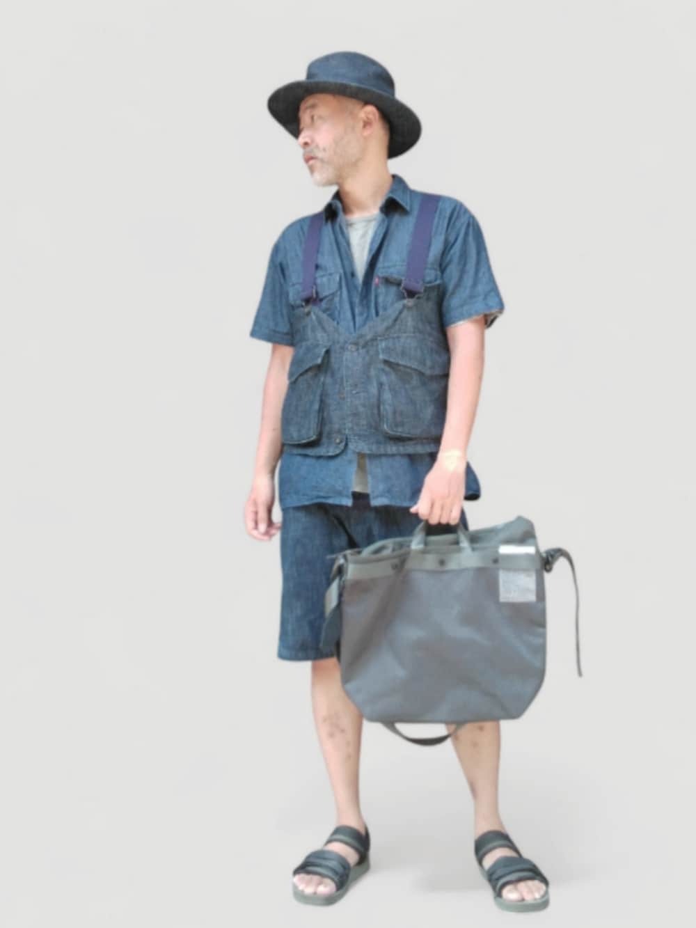 ブラック系のサンダル、ブラック系のショルダーバッグ、ブルー系のベストを着用したメンズの夏コーディネートの2枚目の写真