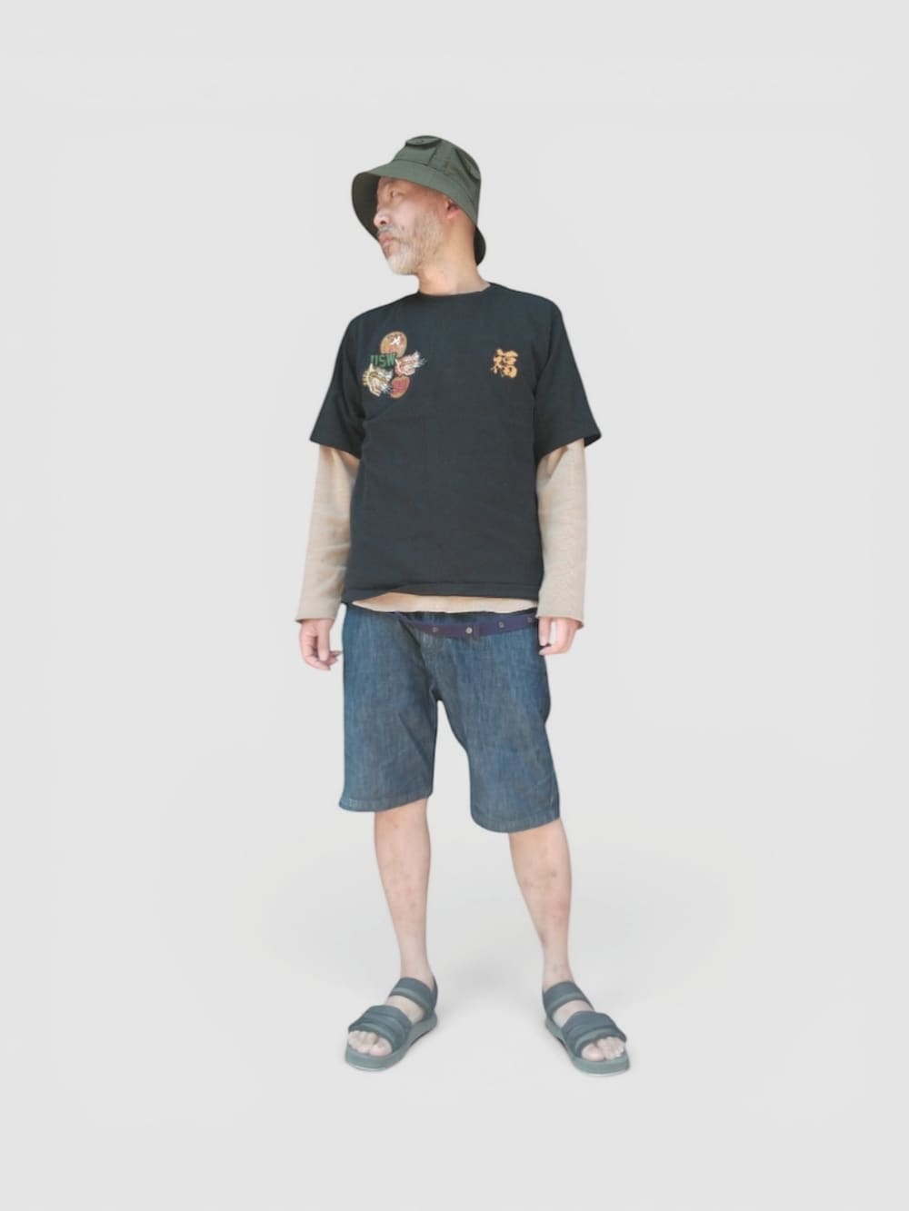 ブルー系のデニムパンツ、ブラック系のサンダル、ブラック系のTシャツ/カットソーを着用したメンズの夏コーディネートの3枚目の写真