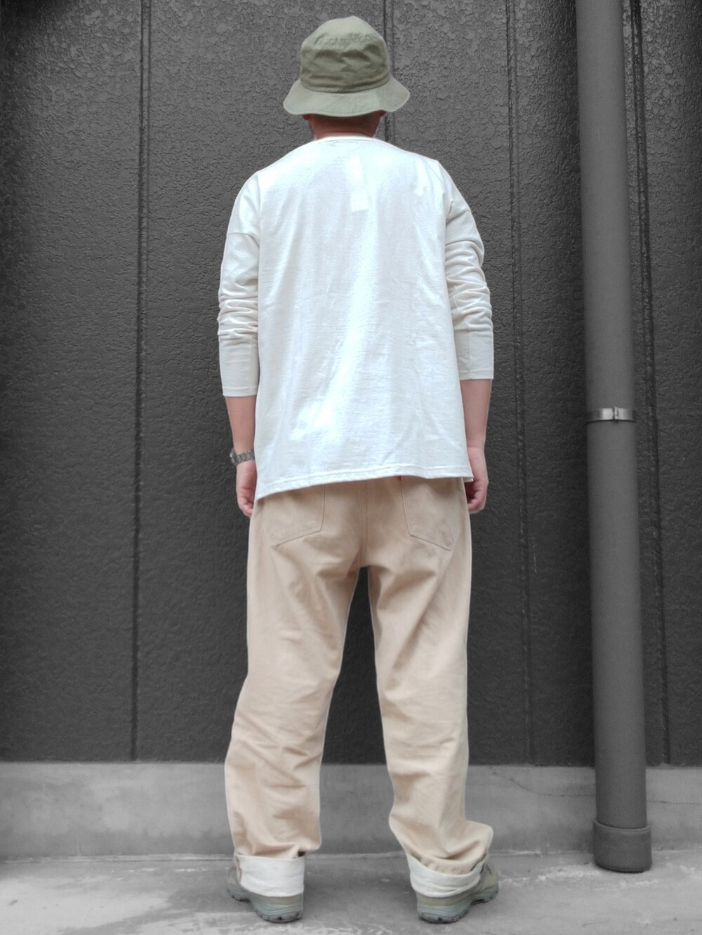 ベージュ系のデニムパンツ、グリーン系のスニーカー、ホワイト系のTシャツ/カットソーを着用したメンズの春コーディネートの5枚目の写真