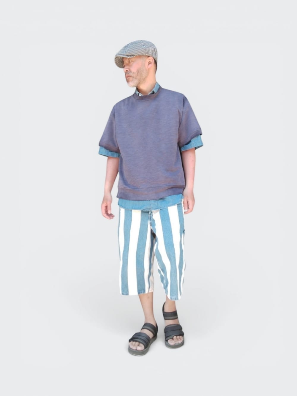 グリーン系のサンダル、ブルー系のパンツ、パープル系のTシャツ/カットソーを着用したメンズの春コーディネートの2枚目の写真