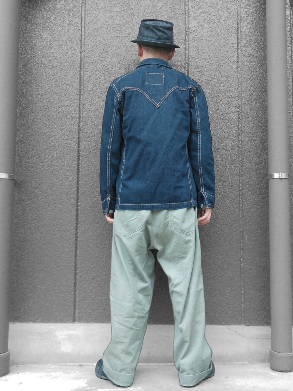 グリーン系のカーゴパンツ、ブルー系のデニムジャケット、ベージュ系のベストを着用したメンズの秋コーディネートの5枚目の写真